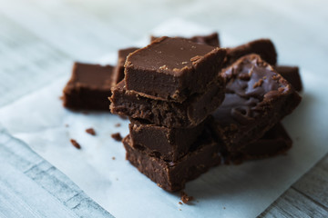 Stack of fudge squares on parchment paper. 