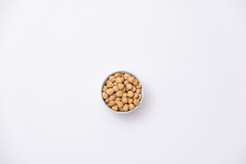 Roasted hazelnuts in a bowl on white background. Isolated baked hazelnuts.