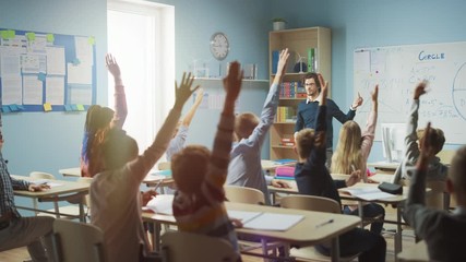 Caring Teacher Explains Lesson to a Classroom Full of Bright Diverse Children. In Elementary School with Group of Smart Multiethnic Kids Learning Science, Whole Classroom Raising Hands Knowing Answer - Powered by Adobe