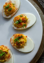 Deviled eggs with paprika on a white serving tray.