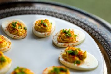 Deviled eggs with scallions and paprika on a serving tray. Close up view. 