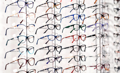 exhibition of glasses at shelves. Fashionable spectacles shown on a wall at the optical shop....