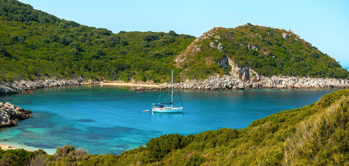 Private yacht anchored in the azure bay near the coast of the Greek island of Corfu