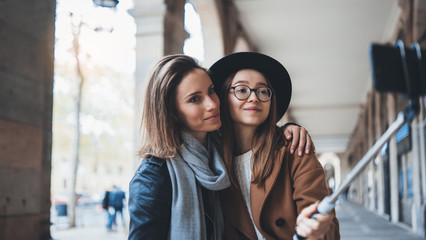 two girlfriends taking photo selfie on smartphone mobile in city. Blogger hipster travels in Barcelona. Holiday friendship concept. Travelers self cellphone internet technology mockup space