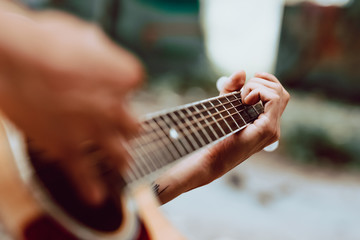 young boy plays the acoustic guitar in abandoned place.