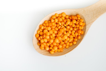 Lentil in a wooden spoon. on white background