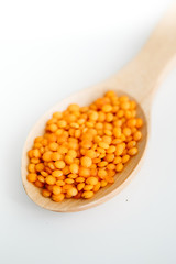 Lentil in a wooden spoon. on white background