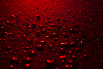 water drops on a plastic red background in the dark