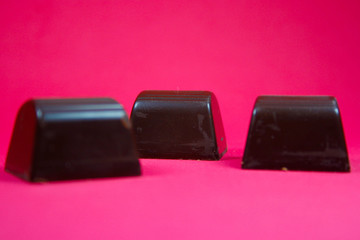 delicious dark chocolate bonbons on red background for dinner or snack