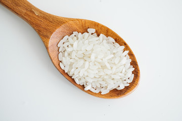 rice grains in wooden spoon