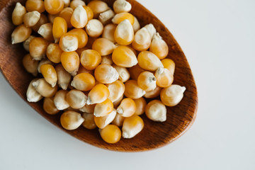 corn grains in wooden spoon