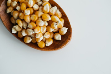 corn grains in wooden spoon