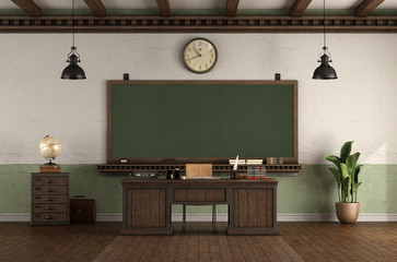 Retro style empty classroom with blackboard and desk teacher's desk