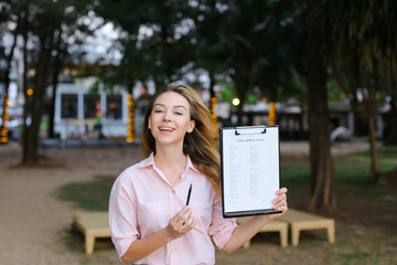 Young girl standing with visa application on resort.