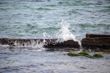 Splashes of water crashing on rocks at sea in autumn