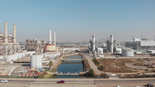 Slow push in toward AES Natural Gas Plant over blue water, Long Beach