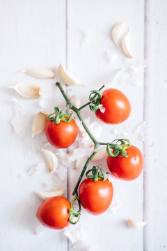 garlic and cherry tomatoes on a white background
