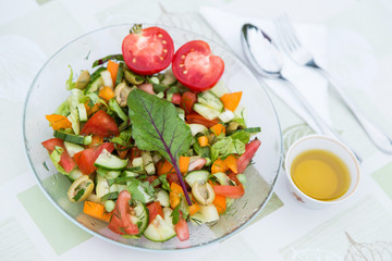Plate with fresh mixed vegetables salad with greens close-up. Vegan vegetarian healthy food	