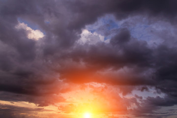 Naklejka na ściany i meble Epic dramatic sunset, sunrise on storm sky with dark clouds, orange yellow sun and sunlight