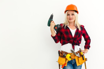 working woman in helmet with tools holding a drill