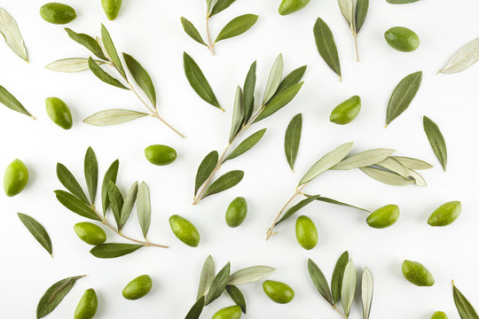 Pattern with green olive fruits with leaves on white background. Top view.