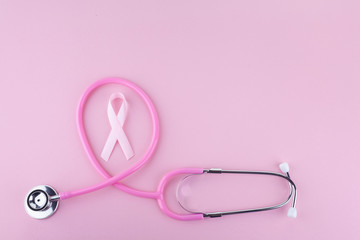 Fototapeta premium Pink ribbon and stethoscope on pink background, Symbol of breast cancer in women, Health care concept