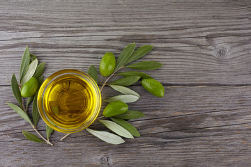 Olive oil and olive branch on wooden background. Top view
