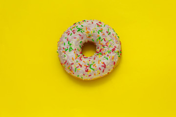 Fototapeta na wymiar donut with colored sugar sprinkles on yellow background