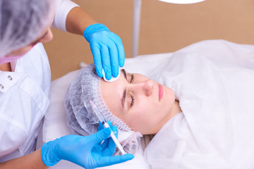 Young woman on rejuvenation procedure in a cosmetology clinic.