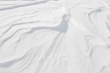 White winter snow on ground texture background. Top down view of natural color of snowy pattern...