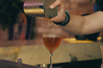 Bartender pouring cocktail at bar counter