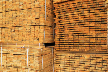 Wooden boards are piled in stacks at the backyard of a construction supermarket. Industrial background, lumber, industrial wood. Pine wood timber for furniture production, construction