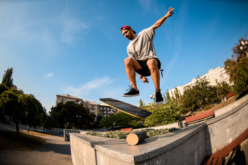 Man jumping on the balance board on the concrete border in the park