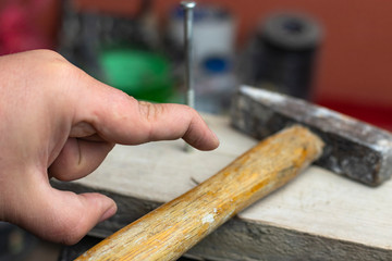 man is trying to hammer a nail. missed and hit my fingers. finger deformity.