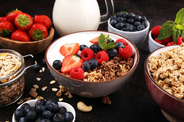 Tasty homemade granola served on table. Healthy breakfast with a bowl of oatmeal with banana, blueberries, strawberries and healthy food for Breakfast