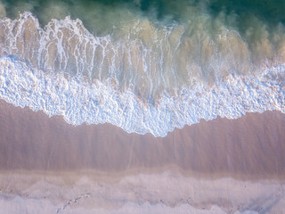 Obraz na płótnie Canvas Drone picture of waves hitting the beach.