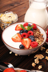 Tasty homemade granola served on table. Healthy breakfast with a bowl of oatmeal with banana, blueberries, strawberries and healthy food for Breakfast