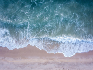 Drone picture of waves hitting the beach.