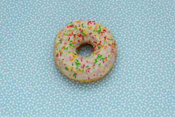 Fototapeta na wymiar donut on blue with pattern background, top view