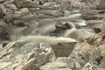 Close up of the silky smooth water flowing across the rocky mountain stream