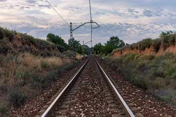 Obraz premium Unique railroad line at the sunset. Train railway track . Low clouds over the railroad.