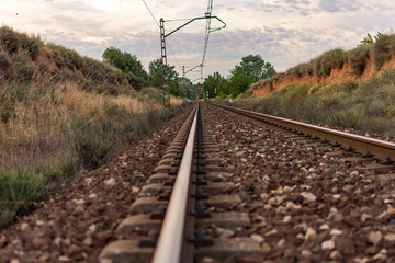 Unique railroad line at the sunset. Train railway track . Low clouds over the railroad.