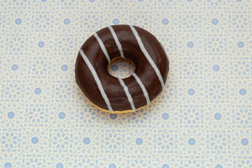 donut on gray with blue pattern background, top view