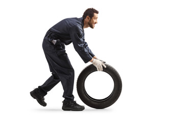 Repairman rolling a car tire