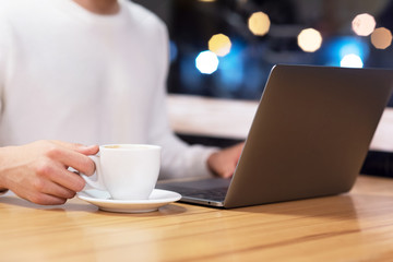 Close Up Of Man With Laptop And Coffee Cup At coffee shop .