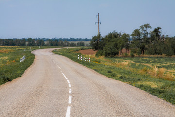 Fototapeta premium Smooth asphalt road to the mountains road to the distance beyond the horizon to the clouds.