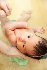 Small nwborn big-eyed beautiful baby bathes