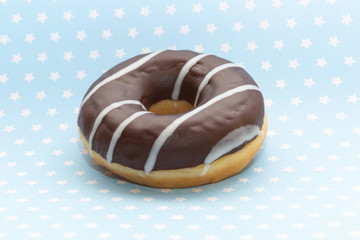 donut on blue with white stars background, close up view