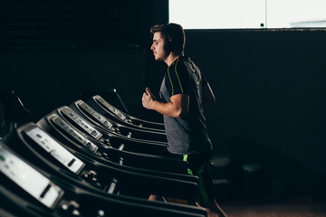 Lonely man running on treadmill at the gym
