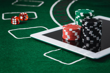 Poker online and gambling concept. Poker chips and a digital table on a green felt